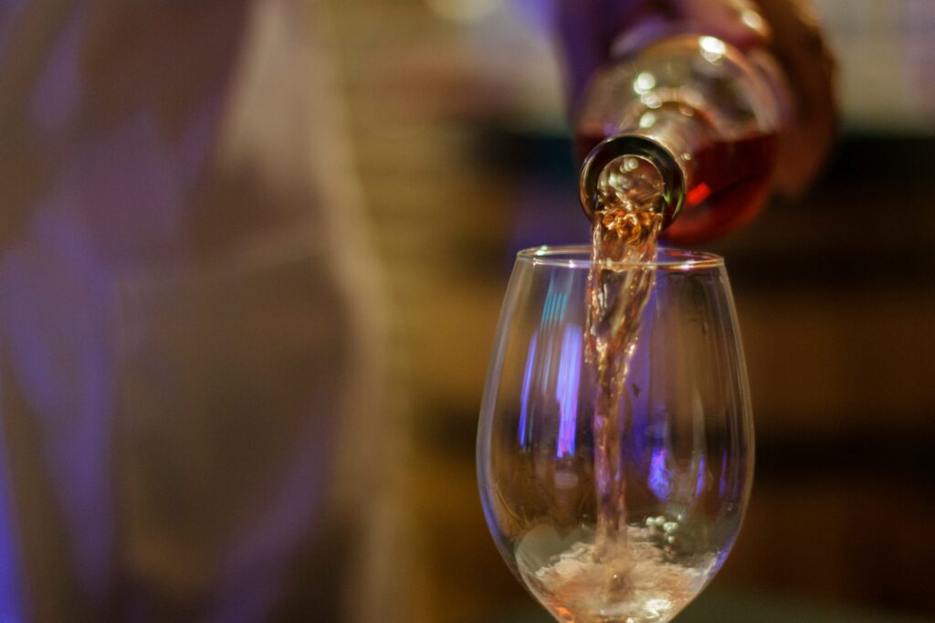 Pouring rose wine in a wine glass,
